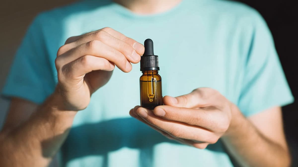 flacon d'huile de CBD sublinguale entre les mains